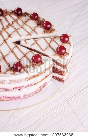 Chocolate cake with mousse decorated with cherries and chocolate. Closeup