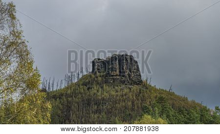 Havrani rock over Jetrichovice village in autumn dark day
