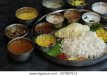 South Indian Vegetarian Thali served in a Round Steel plate selective focus