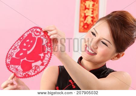 Young woman celebrating Chinese New Year holding paper cutting