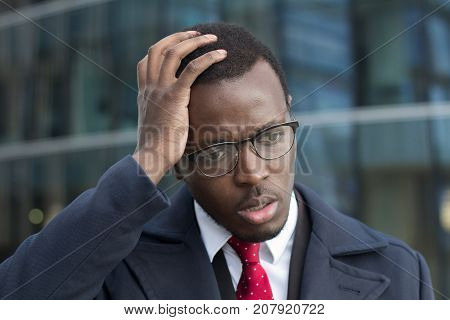 Horizontal Headshot Of Young Dark-skinned Businessman Standing Outdoors With Facepalm Gesture, Touch