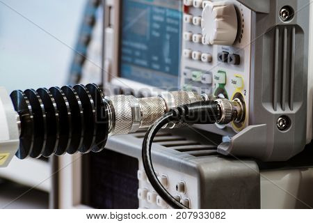 Measuring high-frequency equipment. Special high-frequency connectors are inserted into the instrument panel. Abstract industrial background.