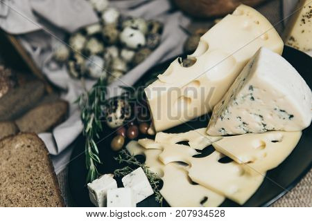Multiple cheese kinds for making sandwiches. Perfect snack for cheese-lovers. Preparing dairy products for dinner or party. Eggs on the background. Ideal recipe.