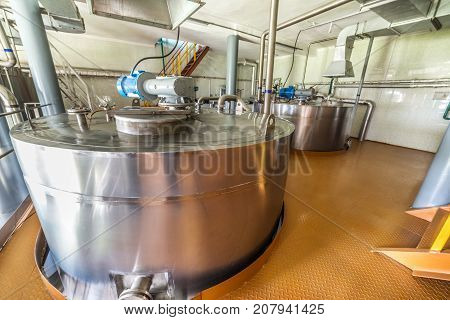 Stainless steel tanks equipped with electric motors and a lot of pipelines. Equipment for mixing sugar and yeast mixture.