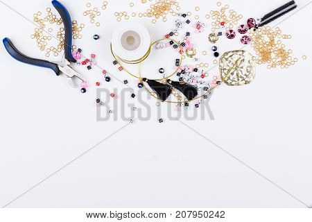Domino beads and components for jewelry making on white background. Top view. Space for text.