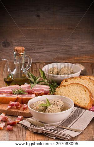 Canederli pasta with bacon on wooden table.