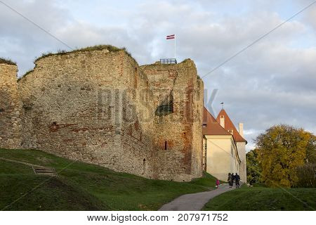 The ruins of the Livonia Order Castle was built in the middle of the 15th century. Bauska Latvia in autumn. Latvian flag on the top of the tower