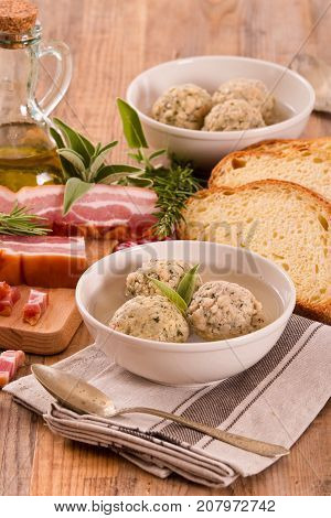 Canederli pasta with bacon on wooden table.