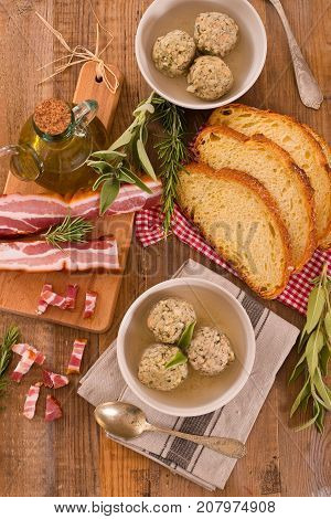 Canederli pasta with bacon on wooden table.