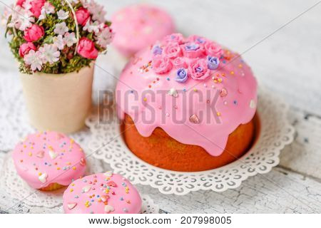 Traditional Easter cake with decorations and cupcakes on wooden table
