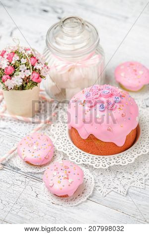 Traditional Easter cake with decorations and cupcakes on wooden table