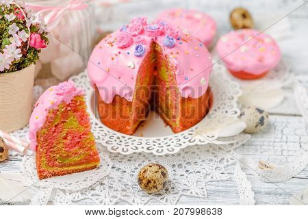 Traditional Easter cake with decorations and cupcakes on wooden table