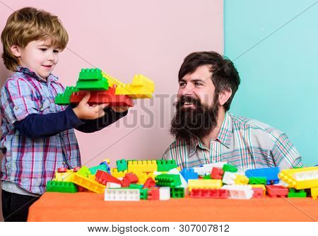 Family Leisure. Father Son Game. Father And Son Create Constructions. Bearded Man And Son Play Toget