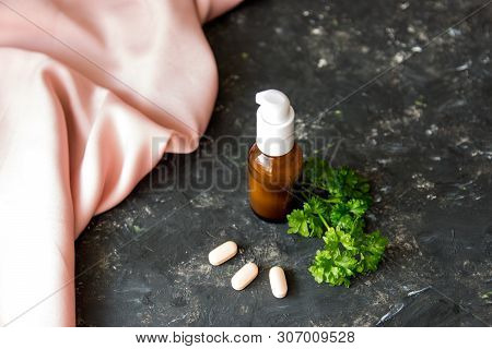 Brown Glass Bottle With Essential Oil Or Creme, Vitaminen And Healing Green Herbs On The Rough Textu