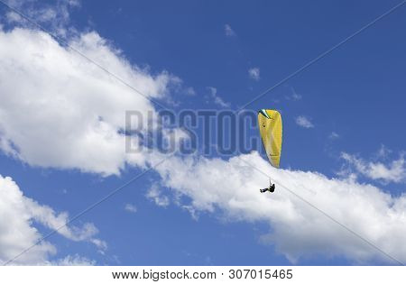 Oostduinkerke, Belgium - June 19, 2019: A Paraglider Is Floatring In The Air Between Wihte Clouds