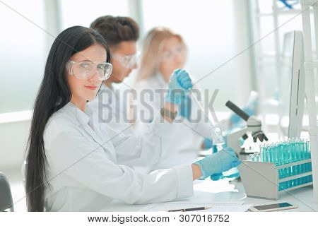 Close Up.modern Woman Sitting With Colleagues At The Laboratory Table.