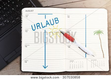 Top View Of Calendar On Table With Word Urlaub, German For Vacation, And Sun Icon Against Wooden Tab