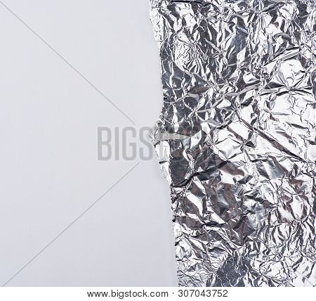 Ragged Edge Of Silver Foil On A White Background, Close Up, Copy Spave