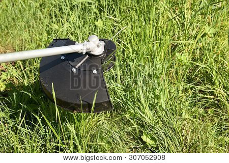 Trimmer Mows Grown Grass On The Lawn Forming A Circle. Trimmer Close Up Mow The Grass With A Lawnmow
