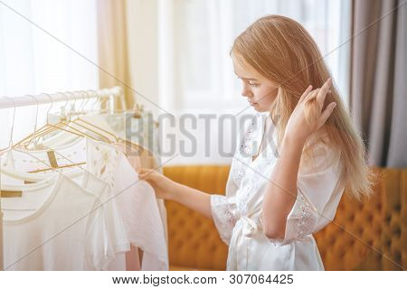 Clothing, Fashion, Style And People Concept - Woman Choosing Clothes At Home Wardrobe