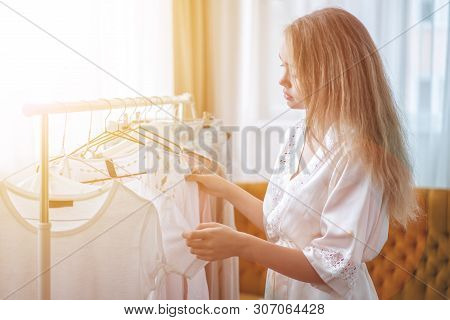Clothing, Fashion, Style And People Concept - Woman Choosing Clothes At Home Wardrobe