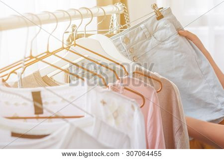 Clothing, Fashion, Style And People Concept - Woman Choosing Clothes At Home Wardrobe