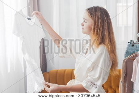 Clothing, Fashion, Style And People Concept - Woman Choosing Clothes At Home Wardrobe