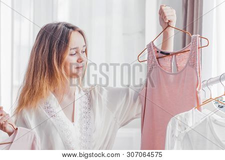 Clothing, Fashion, Style And People Concept - Woman Choosing Clothes At Home Wardrobe