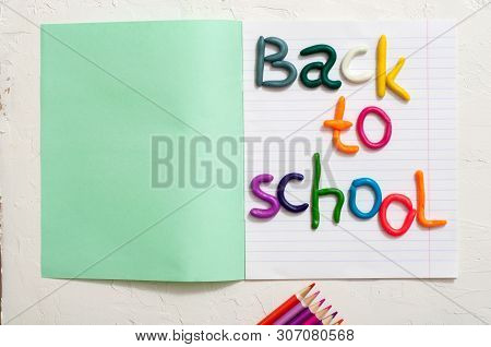 School Supplies And Inscription Back To School On Color Background