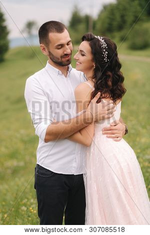 Beautiful Young Wedding Couple Standing On The Green Slope, Hill. Groom And Bride In Carpathian Moun