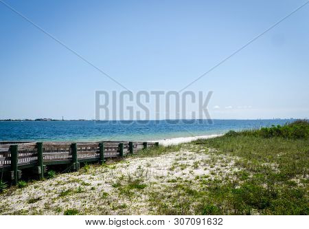 Ramp Walkway Leading To Inter-coastal Bay, Ocean Beach Shoreline With Waves Splashing Onshore. Pensa