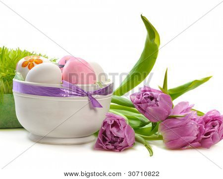  ไข่อีสเตอร์กับดอกทิวลิปและหญ้าสีเขียวบนพื้นหลังสีขาว