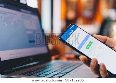 Chiang Mai, Thailand - May 01,2019: Man Holding Xiaomi Mi Mix3 With Facebook App On The Screen. Face