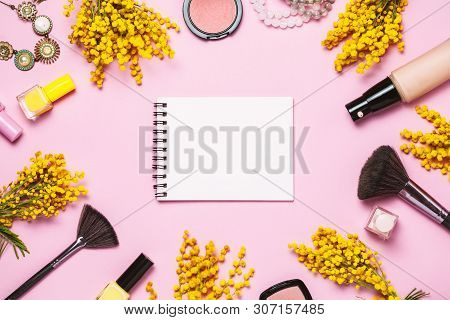 Yellow Spring Flowers, Notebok And Some Cosmetics On Pink Spring Background