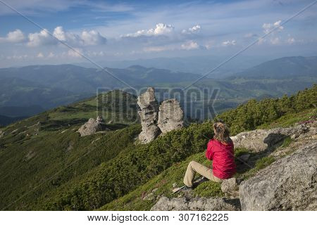 Woman Dressed In Red Jacket Contemplates Mountains Landscape.