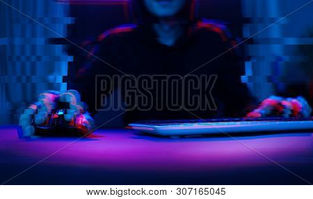 Hacker In The Hood Working With Computer Typing Text In Dark Room. Data Security Concept. Image With