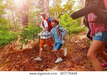 Two Boys Run In Forest Holding Hands