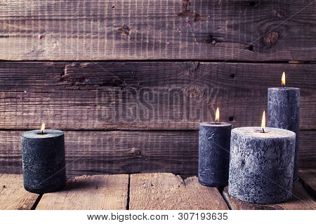 Black  Burning Candles  On Aged  Rustic Wooden Textured Background. Spa Or Still Life Concept. Selec