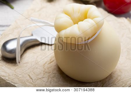 Italian Provolone Or Provola Caciocavallo Hard Cheese In Teardrop Form Served On Old Paper Close Up