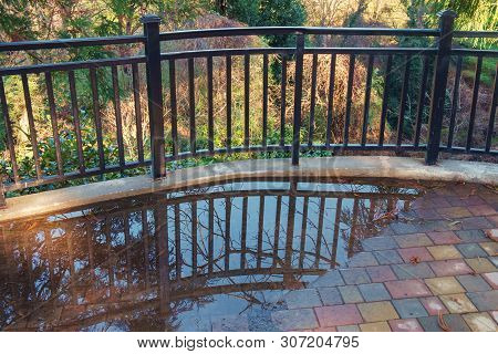 Metal Fence Reflection On The Puddle With Nature Background