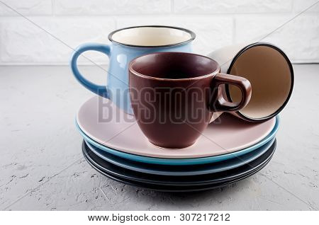 Set Of Clean Ceramic Crockery Tableware On Gray Concrete Background, Color Bowls, Plate, Cup, Dishes