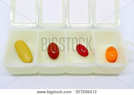 Vibrant Color Assorted Supplement Pills In An Opened White Daily Pill Organizer Case