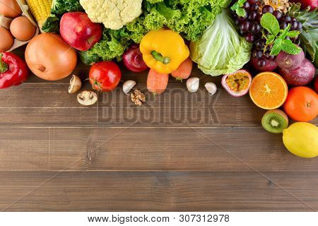 Top View Of Mixed  Colorful Healthy Raw Food In Cluding Vegetables And Fruits On Wood Kitchen Counte