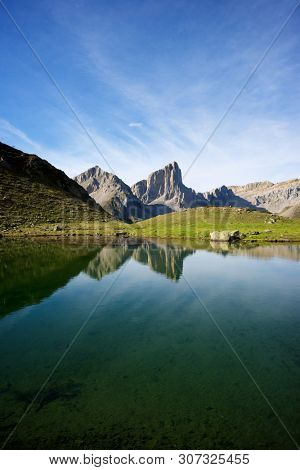 Peaks reflected in Ansabere Lake. Lescun Cirque. Aspe Valley, Pyrenees, France.