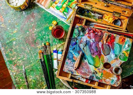 Bright Colorful Workplace Of The Artist With Brushes And Oil Paints