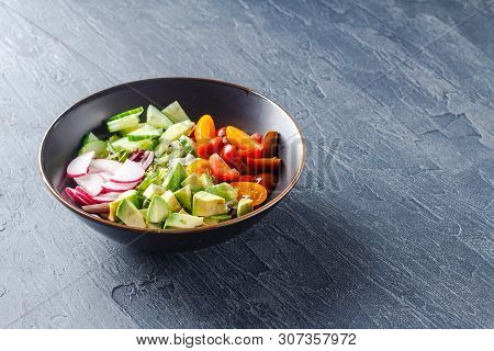 Vegan Buddha Bowl. Bowl With Fresh Raw Vegetables - Cherry Tomatoes, Cucumber, Radish, Avocado, Lett