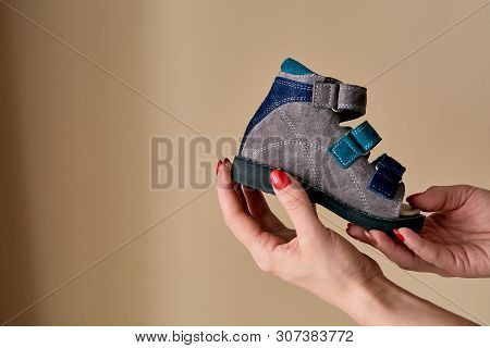 Female Is Holding Close-up A Special Childrens Orthopedic Shoe Sandals Made Of Genuine Leather.