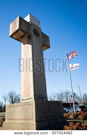 2019 BLADENSBURG MARYLAND USA FEB 25 Peace Cross: Low angle view of American Flag, 100th anniversary Flag at the World War I Memorial commissioned by the American Legion built 1919-1925 on Alt Rt 1.
