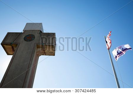 2019 BLADENSBURG MARYLAND USA FEB 25 Peace Cross: Low angle view of American Flag, 100th anniversary Flag at the World War I Memorial commissioned by the American Legion built 1919-1925 on Alt Rt 1.