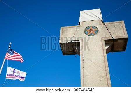 2019 BLADENSBURG MARYLAND USA FEB 25 Peace Cross: Low angle view of American Flag, 100th anniversary Flag at the World War I Memorial commissioned by the American Legion built 1919-1925 on Alt Rt 1.